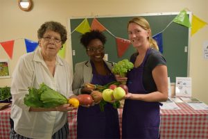 (From left to right) Regency House President Elect of the Resident Council Shirley Pettus, and Iona staff members Jakia Muhammad and Ashlea Steiner show off their colorful spread at the Regency House Farmer's Market. Shirley calls the market a 